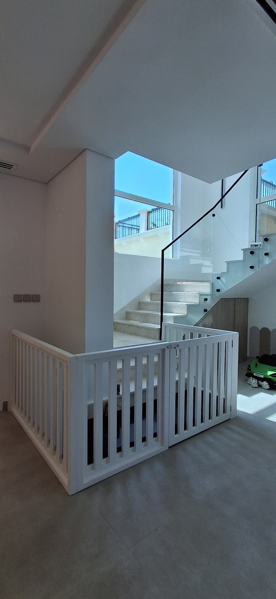 Marble staircase after a white L-shaped safety gate was fitted